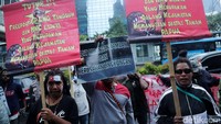 Demonstran membentangkan poster-poster tuntutan di depan kantor PT Freeport Indonesia.