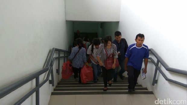Penumpang menyusuri anak tangga di underpass Stasiun Manggarai. 
