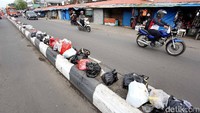 Tumpukan sampah terbungkus dalam sejumlah tas plastik warna-warni dan tergeletak begitu saja di badan jalan.