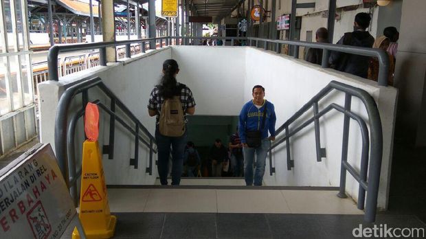Penumpang berjalan melewati underpass di Stasiun Manggarai.