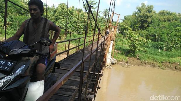 Warga tak memperhitungkan mengindahkan keselamatan jiwanya dengan tetap melintasi jembatan gantung Nambangan yang nyaris ambruk.