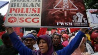 Meski hujan massa tetap berorasi, sembari membawa berbagai banner dan spanduk penolakan.