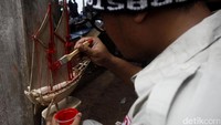 Para risers Datsun melukis miniatur kapal Phinisi di galangan kapal milik Haji Ully.