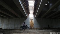 Seorang warga melintas di bawah jembatan Sungai Batu Gingging yang tengah dibangun.