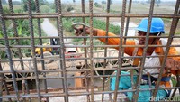 Pekerja menyelesaikan jembatan Sungai Batu Gingging, Pulomiri, Medan.