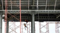Pekerja menyelesaikan pembuatan gerbang tol.