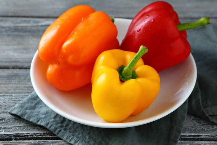 colorful peppers on a white plate, food closeup