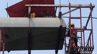 Seorang pekerja tengah menyelesaikan pembangunan.