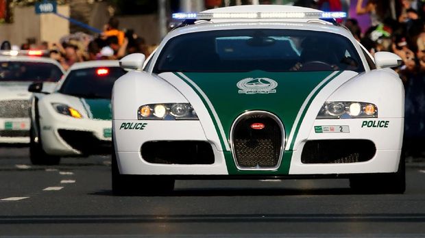 A Dubai police Bugatti leads a convoy of police vehicles: a Lamborghini Aventador and a Bentley as they drive through the streets of downtown Dubai, February 08, 2014.  Dubai police have introduced top end sports cars to their patrol fleet to further strengthen the image of 