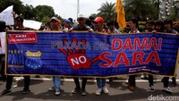 Massa membentangkan spanduk.