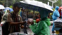 Para pedagang kaki lima (PKL) tetap berjualan meski hujan mengguyur kawasan Masjid Istiqal.