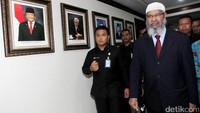 Zakir Naik yang memakai peci putih dan jas bernuansa gelap, lalu menuju ke ruangan Zulkifli.