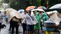 Sebagian peserta aksi datang dengan membawa payung dan jas hujan.