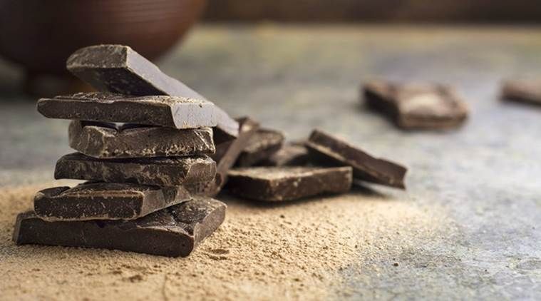 pieces of dark chocolate stacked on grunge background