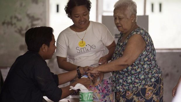 Warga mencelupkan jari ke tinta usai menggunakan hak pilihnya