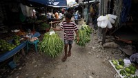 Seorang bocah terlihat memikul beberapa ikat sayur-mayur di Pasar Rakyat Atambua, Kabupaten Belu, Nusa Tenggara Timur, belum lama ini.