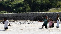 Warga Timor Leste menyeberangi sungai Malibaka untuk berbelanja di Pasar Turiskain, Indonesia. (Grandyos Zafna/detikcom)