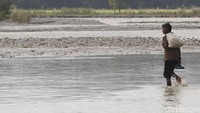 Seorang WNA Timor Leste kembali bersiap menyeberangi sungai uasai berbelanja.