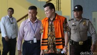 Andi Narogong keluar gedung KPK dengan memakai rompi tahanan. Pengusaha yang kerap disebut dalam persidangan sebagai orang yang berperan meloloskan anggaran dan mengatur proses lelang hingga pengadaan itu juga sempat melempar senyuman.