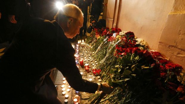 Vladimiri Putin saat meletakkan karangan bunga di dekat lokasi ledakan di St Petersburg