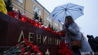 Seorang wanita meletakan karangan bunga. REUTERS/Maxim Shemetov.