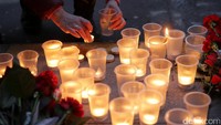 Warga juga menyalakan lilin untuk mengenang para korban. REUTERS/Anton Vaganov.
