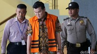 Andi Narogong keluar gedung KPK dengan dikawal polisi.