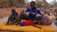Seorang warga dengan 2 anaknya duduk di pengungsian menanti bantuan. REUTERS/Zohra Bensemra.