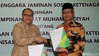 Dirut BPJS-TK Agus Susanto (kiri) saat berjabat tangan dengan Ketua Umum PP Muhammadiyah, Haedar Nashir.