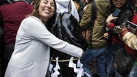 Traveler yang tengah memeluk sebuah ikon penis dari kayu. Hal itu dipercaya dapat memberikan kesuburan dan perlindungan (Behrouz Mehri/AFP)