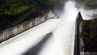 Air dari waduk tampak seperti air terjun yang mengalir deras ke sungai.