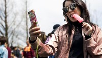 Wanita Jepang yang tengah selfie sambil menjilat permen berbentuk penis. Jangan berpikir negatif ya (Behrouz Mehri/AFP)