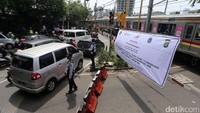 Para petugas mengatur arus lalu-lintas saat ujicoba penutupan perlintasan kereta api Pejompongan I, Jakarta Pusat, Jumat (7/4/2017).