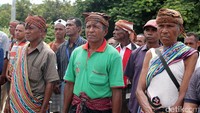Di sisi jembatan bercat merah-kuning-hitam, pihak dari Timor Leste sudah siap menerima pusaka itu. Ada empat orang, terdiri atas tiga pria paruh baya dan satu perempuan. Semuanya mengenakan kain tais, dilengkapi dengan penutup kepala batik yang dikenakan tiga pria itu.