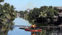  Meski hari Minggu, para petugas Pekerja Penanganan Sarana dan Prasarana Umum (PPSU) atau dikenal sebagai Pasukan Oranye tetap bekerja membersihkan Kali Tirem, Tanjung Priok. 