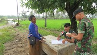Ada portal dan meja tempat anggota TNI memeriksa pelintas batas. Seorang ibu tertawa sambil berbincang dengan petugas TNI (Fitraya/detikTravel)