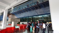 Para calon penumpang pesawat mengantre di bawah proyek skytrain Bandara Soekarno-Hatta.