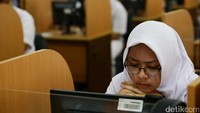 Ujian dumulai, seorang siswa namp-ak sangat serius saat mengerjakan soal.