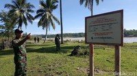 Aparat TNI menunjukan plan tanda perbatasan Indonesia dan Timor Leste. Di seberang Sungai Malibaka adalah negara Timor Leste (Fitraya/detikTravel)