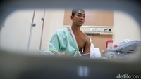 Sementara lengan baju kirinya terbuka, memperlihatkan jelas tangan kirinya yang ditopang kain penyangga dan bagian bahu yang ditempel perban besar.