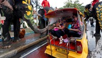 Seekor Gajah menyemprot wisatawan dengan air saat perayaan Festival Air Songkran di Ayutthaya, Bangkok, Thailand, Selasa (11/4).  REUTERS / Chaiwat Subprasom