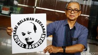Busyro saat memegang poster dukungan untuk Novel Baswedan.
