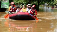 Perahu karet hilir mudik di perumahan tersebut untuk mengevakuasi warga.