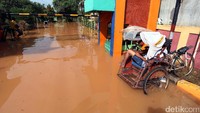 Becak tetap mangkal meski banjir merendam perumahan tersebut.