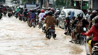Banjir menyebabkan ratusan kendaraan baik roda empat maupun roda dua terjebak dalam antrian dan tak bisa bergerak.