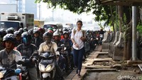 Seorang pejalan kaki melintas di pedestrian yang tersisa di sepanjang jalan Pancoran.
