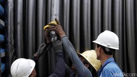 Pekerja menutup potongan kabel menggunakan solatif.