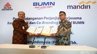 Direktur SDM dan Hukum PT Semen Indonesia Agung Yunanto (kiri) dan Direktur Digital Banking & Techology Bank Mandiri Rico Usthavia Frans (kanan) menunjukkan naskah kerja sama yang telah ditandatangani.