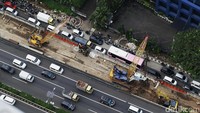 Selain itu, terlihat juga petugas sedang melakukan pekerjaannya. Ada juga ekskavator  sedang mengeruk tanah di lokasi.
