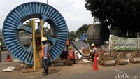 Sejumlah pekerja beristirahat sejenak di antara gulungan kabel yang akan dipasang.